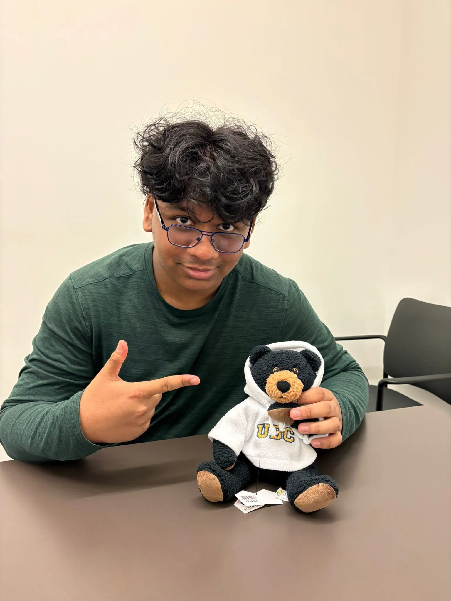 Kaushal grinning with a UBC teddy bear